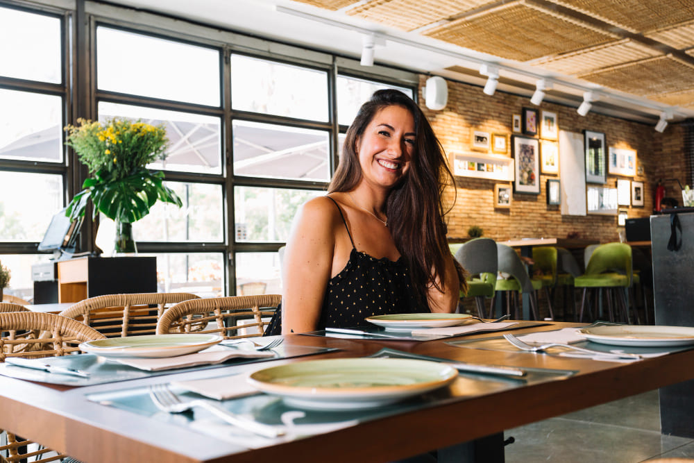 sorrindo-elegante-mulher-jovem-sentando-em-a-restaurante